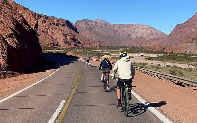 Ciclistas por la ruta entre cerros rojos