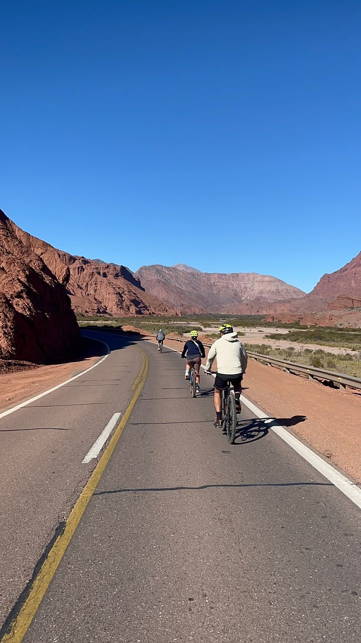 Ciclistas por la ruta entre cerros rojos